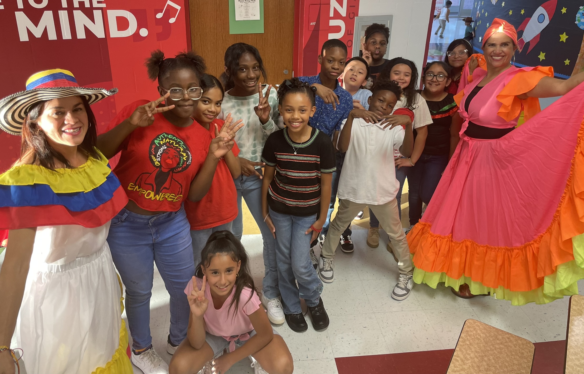 International teacher posing with her class in cultural dress