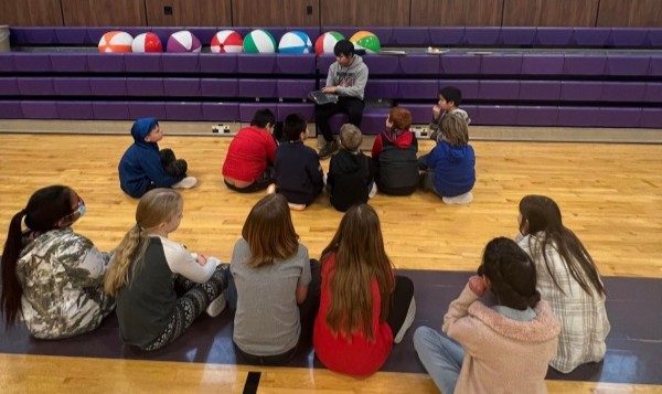 International teacher teaching students who are sat in front of him paying close attention